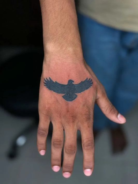Simple Small Blackwork Eagle Tattoo on Men Hand by @kabirainktattooandpiercing