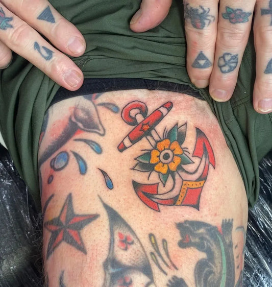Small American Traditional Anchor Flower Tattoo on Men Leg by @darcyisradtattooist