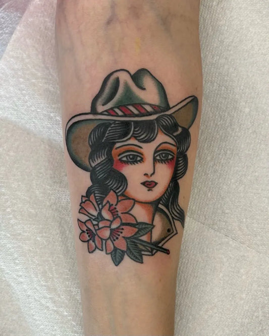 Small American Traditional Cowgirl with Flowers on Women Forearm Tattoo by @hubert_serrano