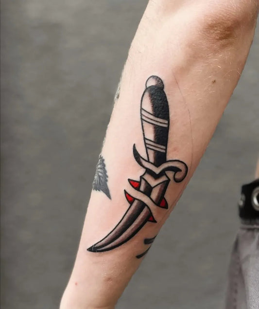 Small American Traditional Dagger Tattoo on Women Arm by @sthlmclassictattoo