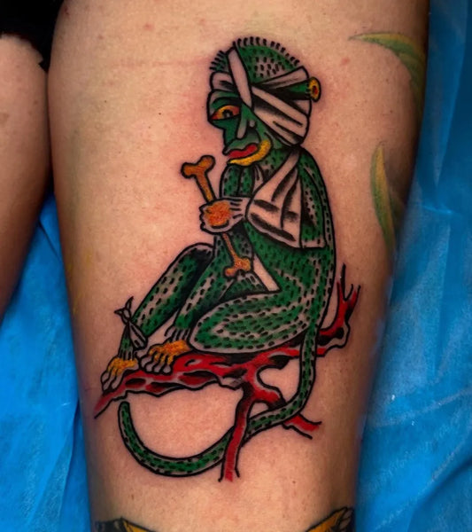 Small American Traditional Green Bandaged Monkey with Bone on Men Leg Tattoo by @chasefenner