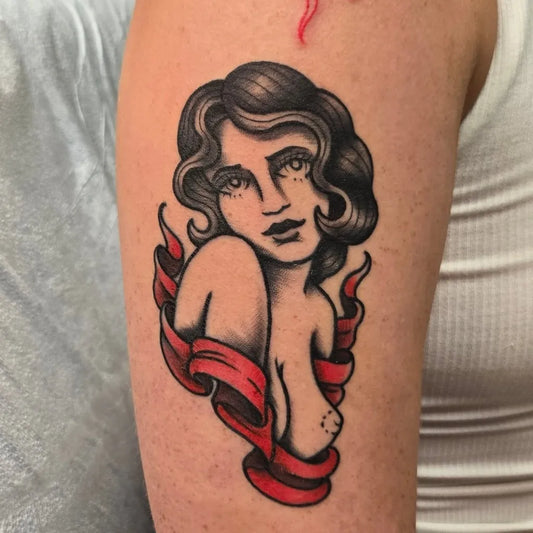 Small American Traditional Pinup girl with flames and ribbons on Women Arm Tattoo by @lucas_buckley_tattoos