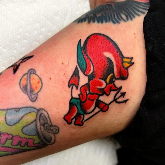 Small American Traditional Red Devil with Trident and Can on Women Arm Tattoo by @cavallo.tattoo