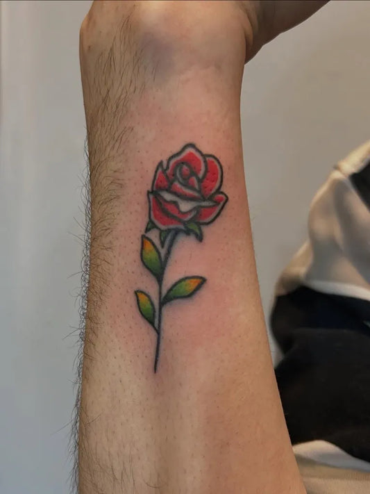 Small American Traditional Red Rose with Leaves on Men Wrist Tattoo by @scott_leblanc_
