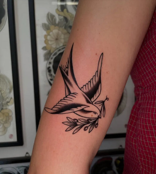 Small American Traditional Sparrow with Olive Branch Tattoo on Women Forearm by @nikkififtysixx