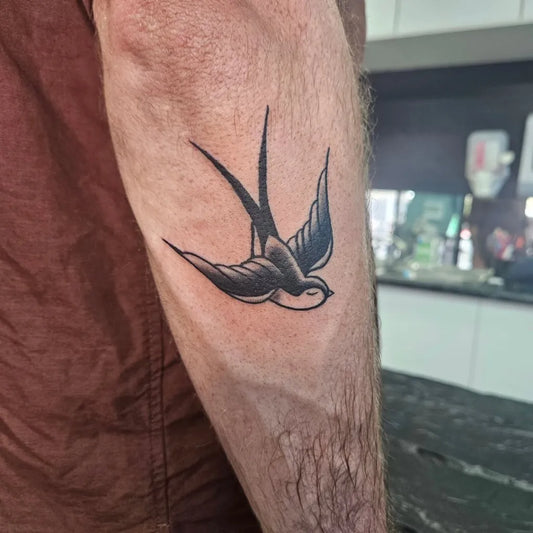 Small American Traditional Swallow Tattoo on Men Arm by @tammy.s.tattoo