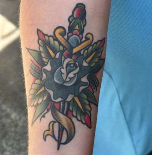 Small American Traditional dagger rose scroll on Men Arm Tattoo by @selfcaretattooco