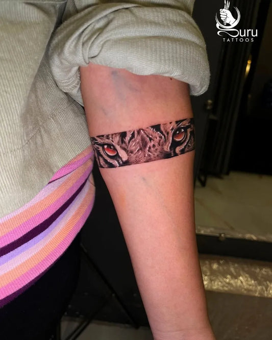 Small Band Tiger Eyes on Women Forearm Tattoo by @gurutattoos