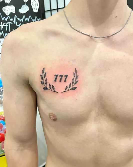 Small Black and Grey 777 Laurel Wreath Tattoo on Men Chest by @minimaltattoo_praha
