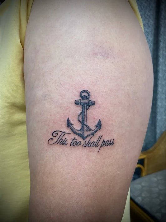 Small Black and Grey Anchor with This Too Shall Pass Text Tattoo on Women Upper Arm by @traceinktattoos