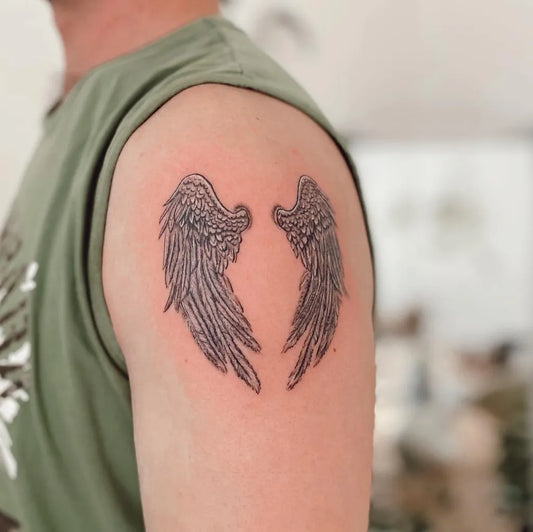 Small Black and Grey Angel Wings Tattoo on Men Shoulder by @bellatattstudio