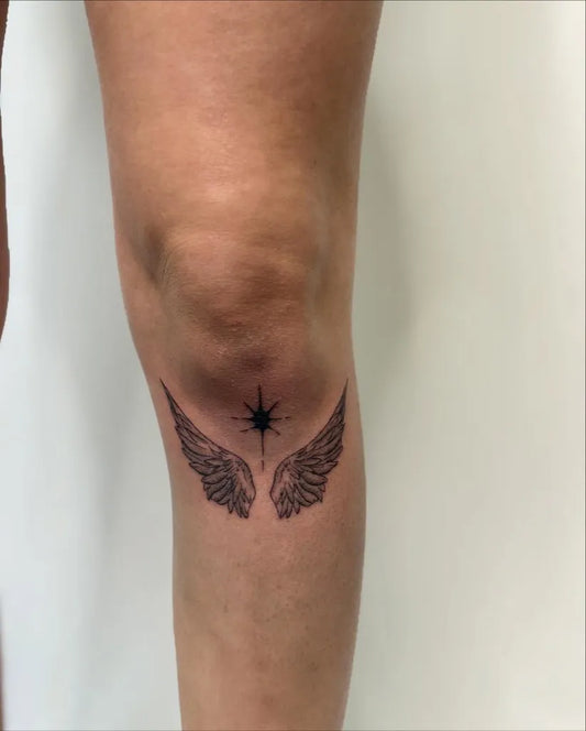 Small Black and Grey Angel Wings and Star Tattoo on Women Knee by @aysiatat222