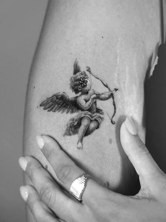 Small Black and Grey Angel with Bow on Women Thigh Tattoo by @_mircomartini