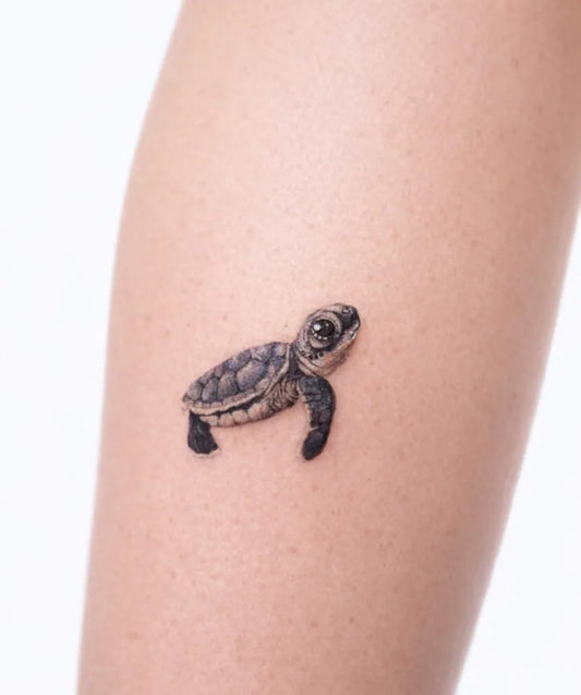 Small Black and Grey Baby Turtle Tattoo on Women Leg by @yenitattooer