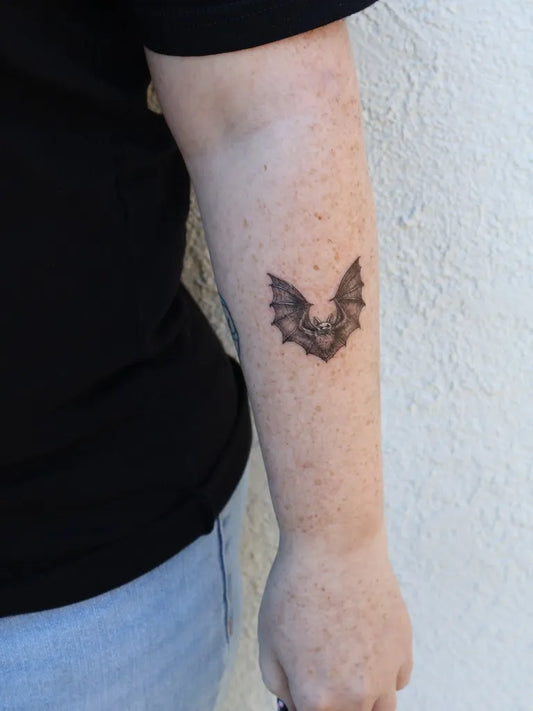 Small Black and Grey Bat Tattoo on Women Arm by @monte_livingston