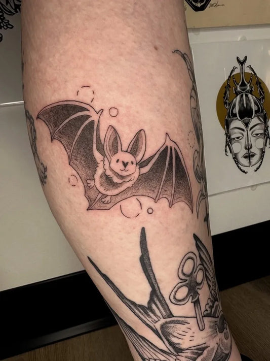 Small Black and Grey Bat Tattoo on Women Leg by @hrtshpdfruit