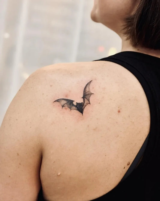 Small Black and Grey Bat Tattoo on Women Shoulder by @bnanatattoo
