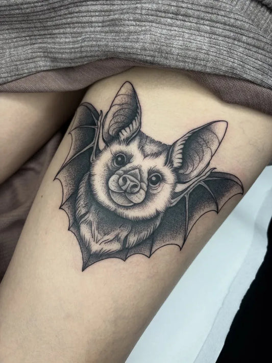 Small Black and Grey Bat Tattoo on Women Thigh by @melxbe.tattoo