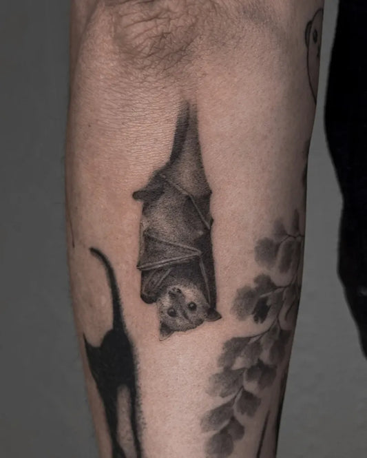 Small Black and Grey Bat and Cat Tattoo on Men Arm by @kavi_tattoo