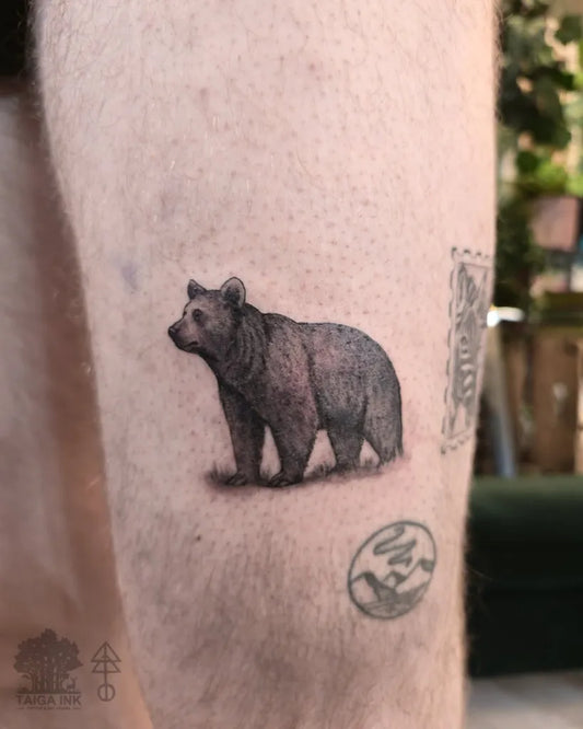 Small Black and Grey Bear on Men Leg Tattoo by @taigaink