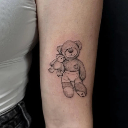 Small Black and Grey Bear with smaller bear on Women Arm Tattoo by @pins.n.needles.gee
