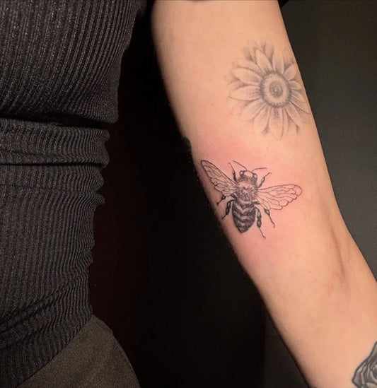 Small Black and Grey Bee and Daisy on Women Arm Tattoo by @dla__fabuly