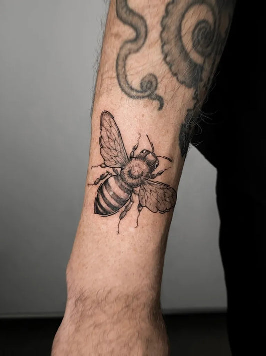 Small Black and Grey Bee on Men Arm Tattoo by @tahinos.tattoo