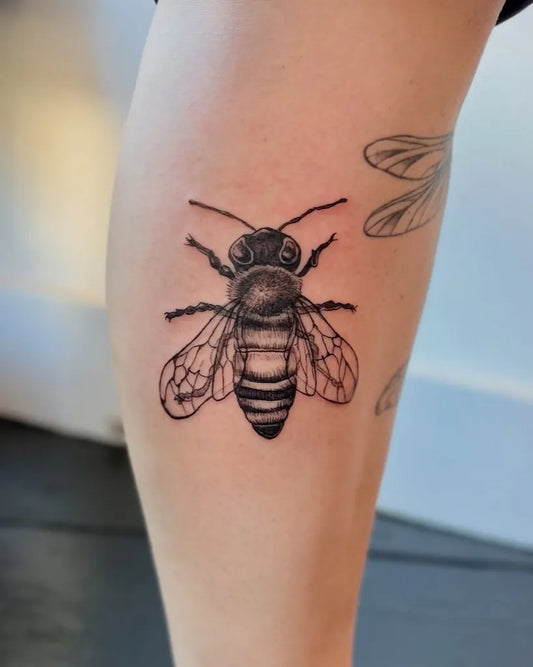 Small Black and Grey Bee on Women Leg Tattoo by @fresh.ink.anna