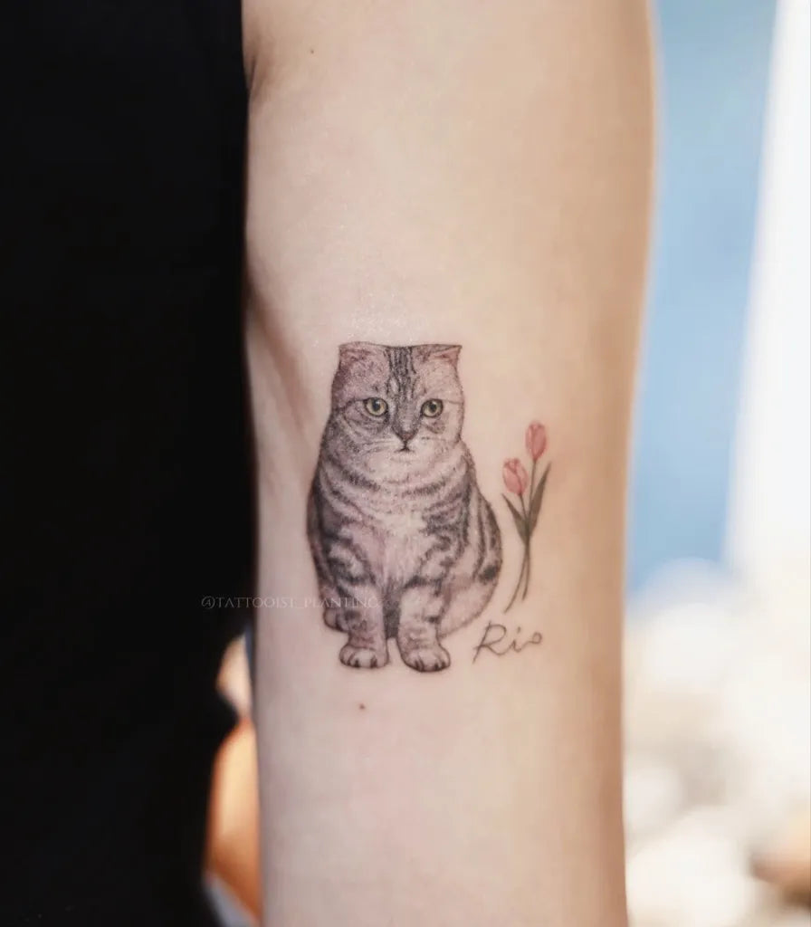 Small Black and Grey Cat with Flowers Tattoo on Women Arm by @tattooist_planting