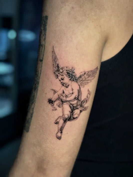 Small Black and Grey Cherub Tattoo on Women Arm by @jayke_cox
