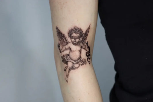 Small Black and Grey Cherub Tattoo on Women Arm by @kayatatt