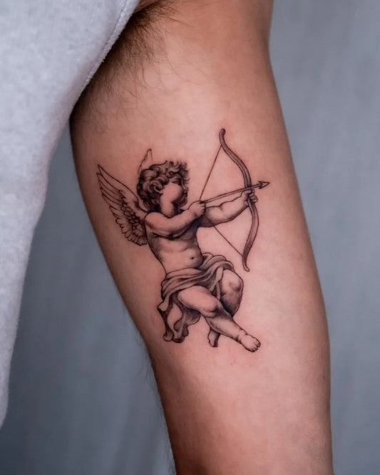 Small Black and Grey Cherub with Bow Tattoo on Men Arm by @tattooist.jev