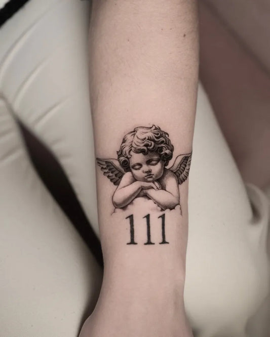 Small Black and Grey Cherub with Number 111 Tattoo on Women Wrist by @t.moretti.tattoo