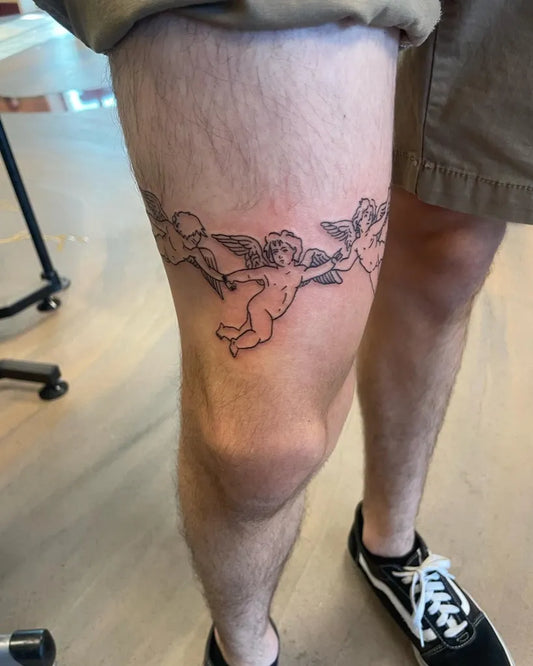 Small Black and Grey Cherubs Tattoo on Men Thigh by @anberlyntattoo