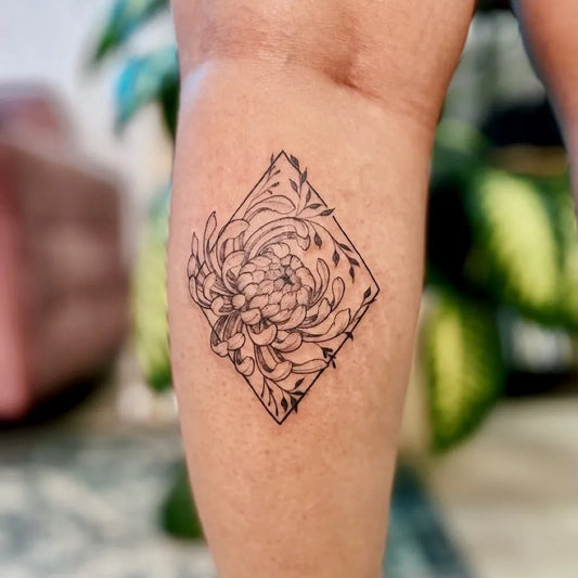 Small Black and Grey Chrysanthemum and Leaves Tattoo on Women Thigh by @carolinastattoo