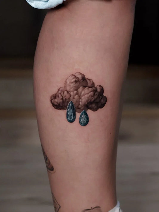 Small Black and Grey Cloud with Raindrops Tattoo on Women Thigh by @karla.guard