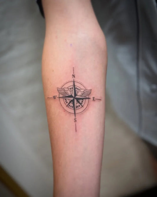 Small Black and Grey Compass with Wings on Women Forearm Tattoo by @libertycentertattooshop