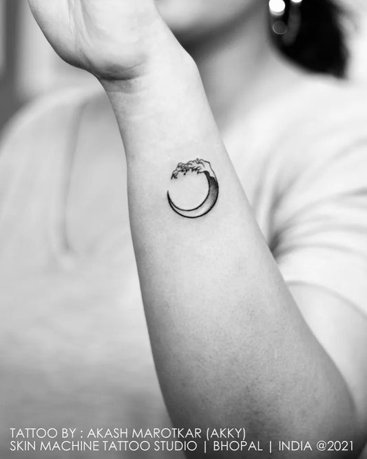 Small Black and Grey Crescent Moon Wave Tattoo on Women Wrist by @skinmachinetattoo