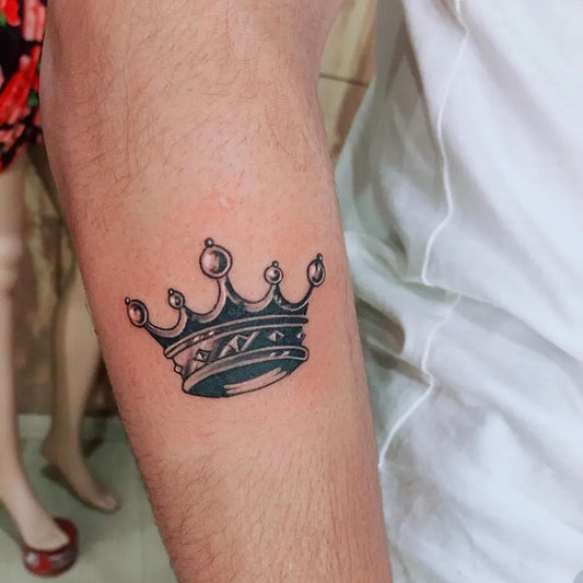 Small Black and Grey Crown Tattoo on Men Arm by @royal_tattoostudio