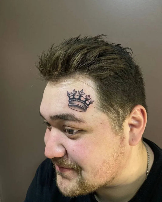 Small Black and Grey Crown Tattoo on Men Face by @tattoo_villa