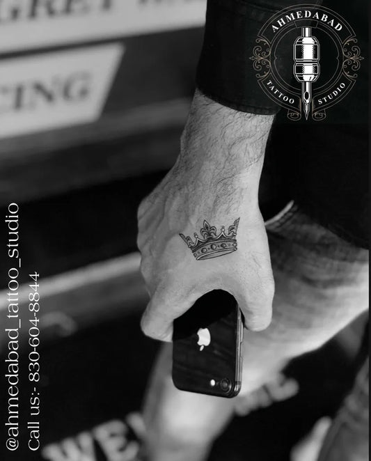 Small Black and Grey Crown Tattoo on Men Hand by @ahmedabad_tattoo_studio