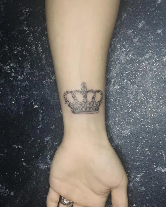 Small Black and Grey Crown Tattoo on Women Wrist by @mewink_artattoo