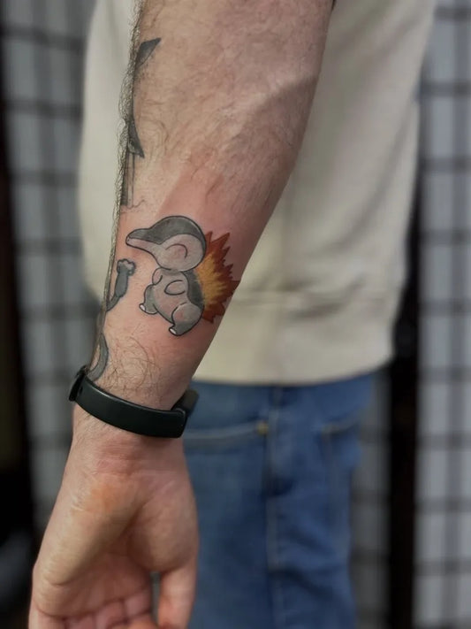 Small Black and Grey Cyndaquil Tattoo on Men Wrist by @katenashtattoos