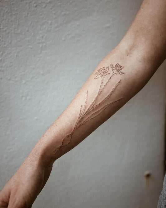 Small Black and Grey Daffodil Tattoo on Women Arm by @floating__lines__