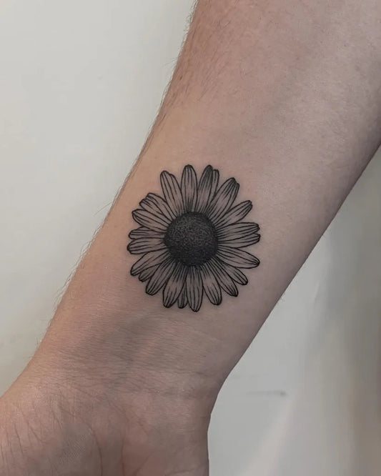Small Black and Grey Daisy Tattoo on Men Wrist by @leo.tattooer
