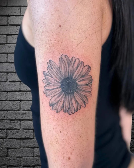 Small Black and Grey Daisy Tattoo on Women Arm by @mr.inkwells