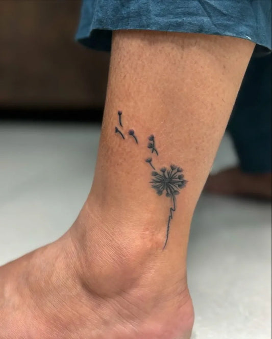 Small Black and Grey Dandelion Tattoo on Women Ankle by @kabirainktattooandpiercing