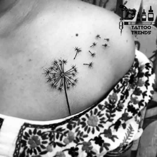 Small Black and Grey Dandelion Tattoo on Women Shoulder by @tattootrendsbangalore