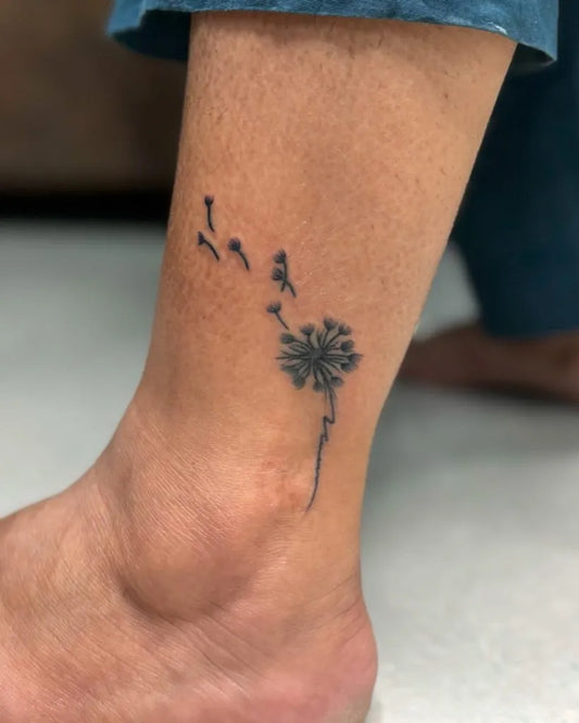 Small Black and Grey Dandelion and Birds Tattoo on Women Ankle by @kabirainktattooandpiercing