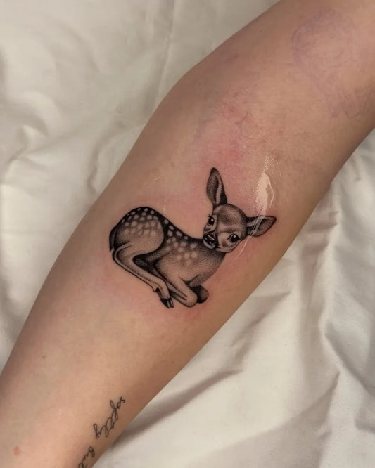 Small Black and Grey Deer Tattoo on Women Arm by @julesrose.tattoos